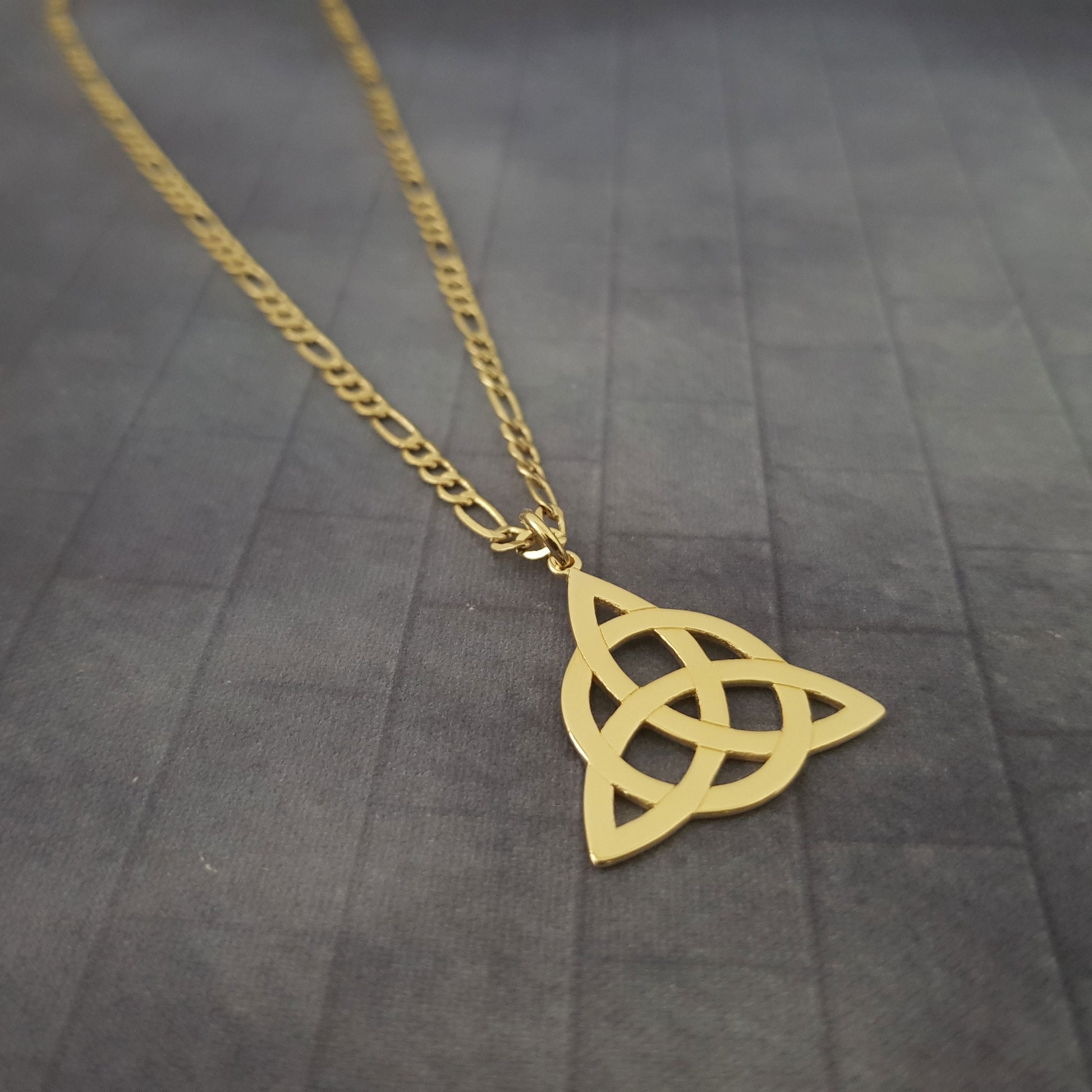 a gold necklace with a celtic knot on it