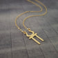 a gold necklace with an omen symbol on it