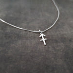 a silver necklace with a cross on it