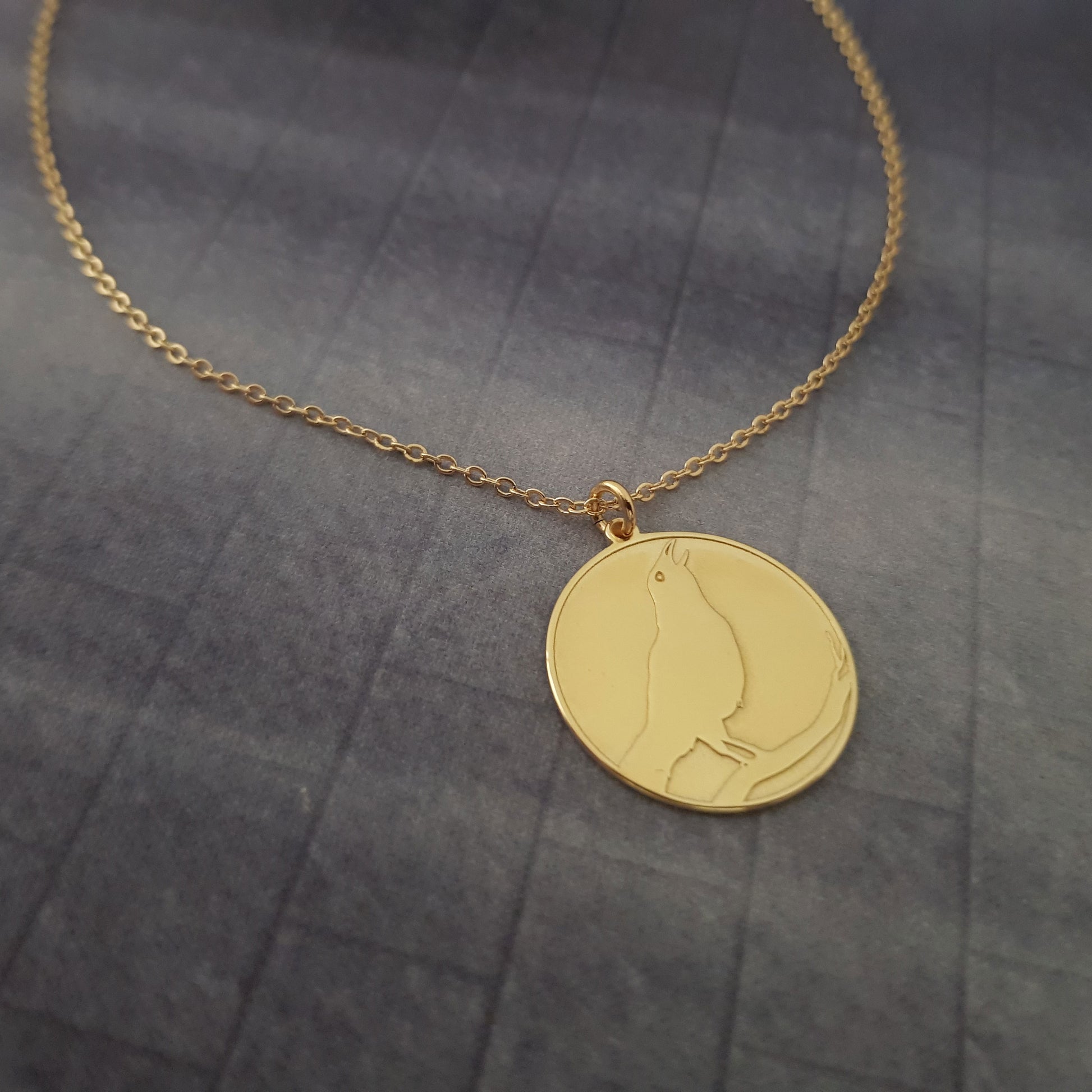 a gold necklace with a cat on it