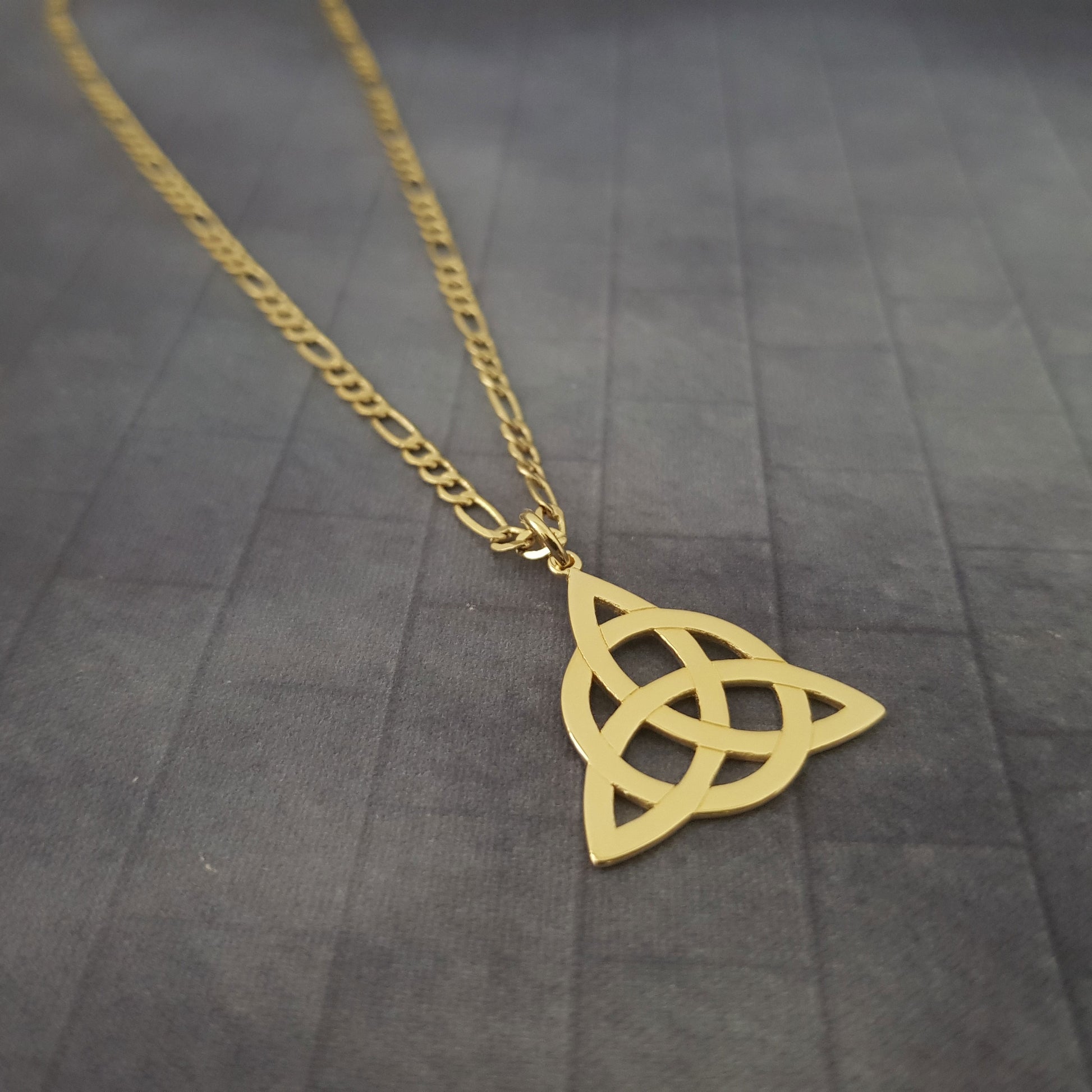 a gold necklace with a celtic knot on it