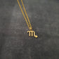 a gold necklace with the letter m on it