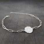 a silver bracelet with a flower on it