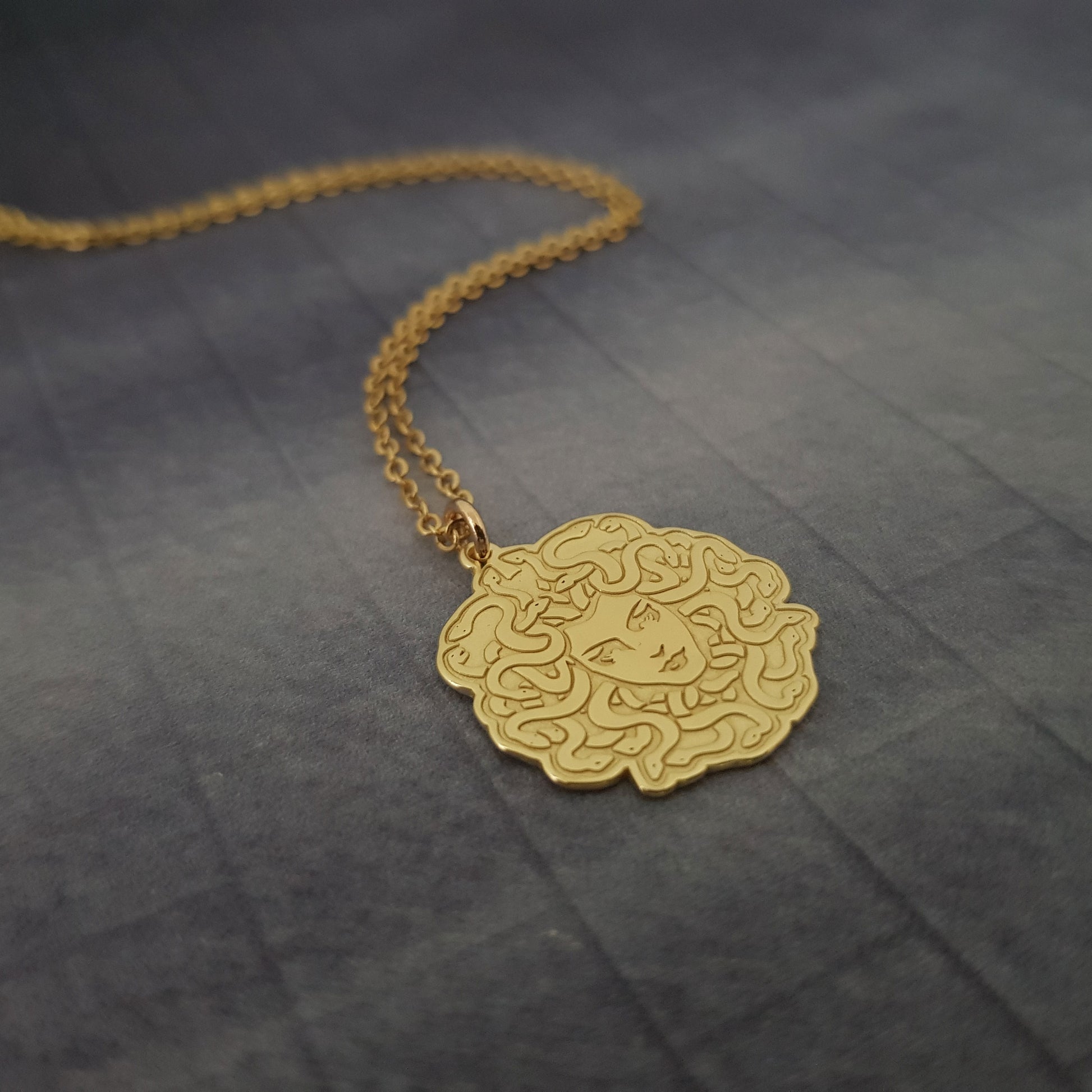 a gold necklace with an intricate design on it