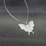 a silver necklace with a butterfly on it