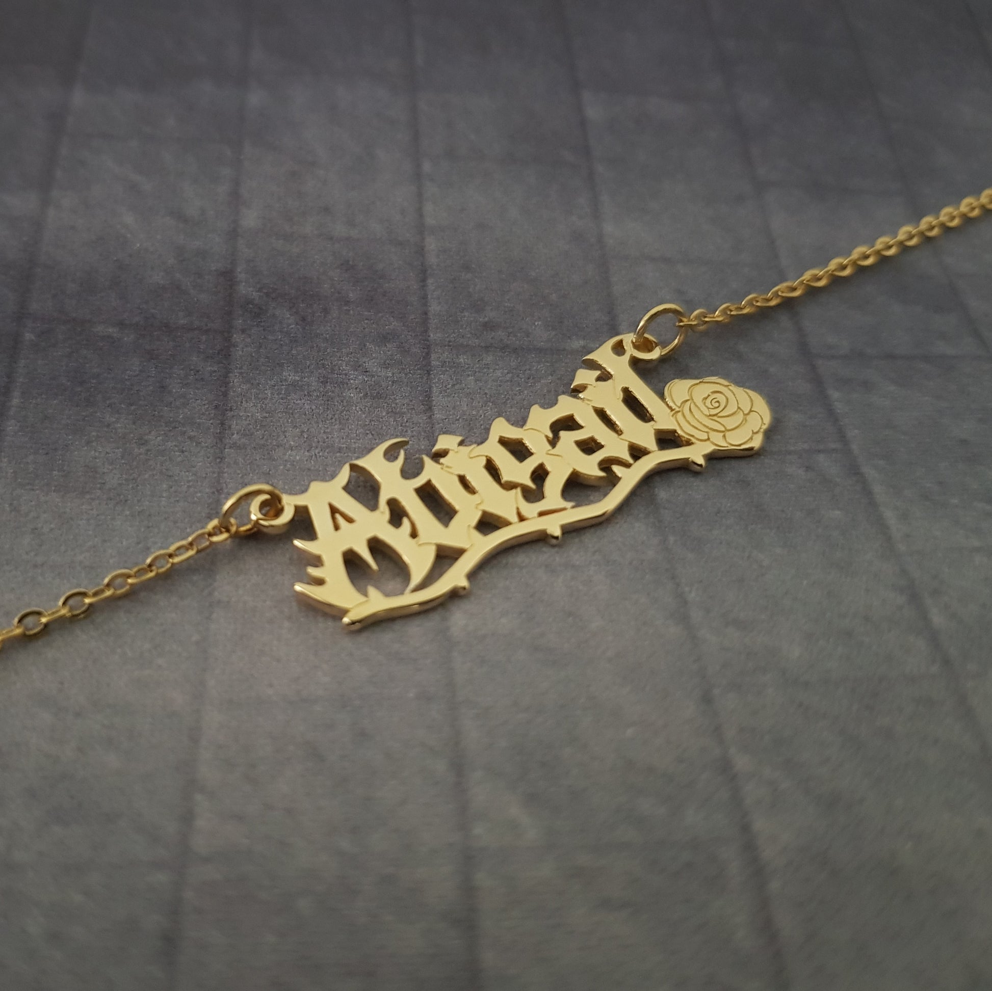 a gold plated necklace with a name on it