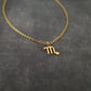 a gold necklace with the letter m on it