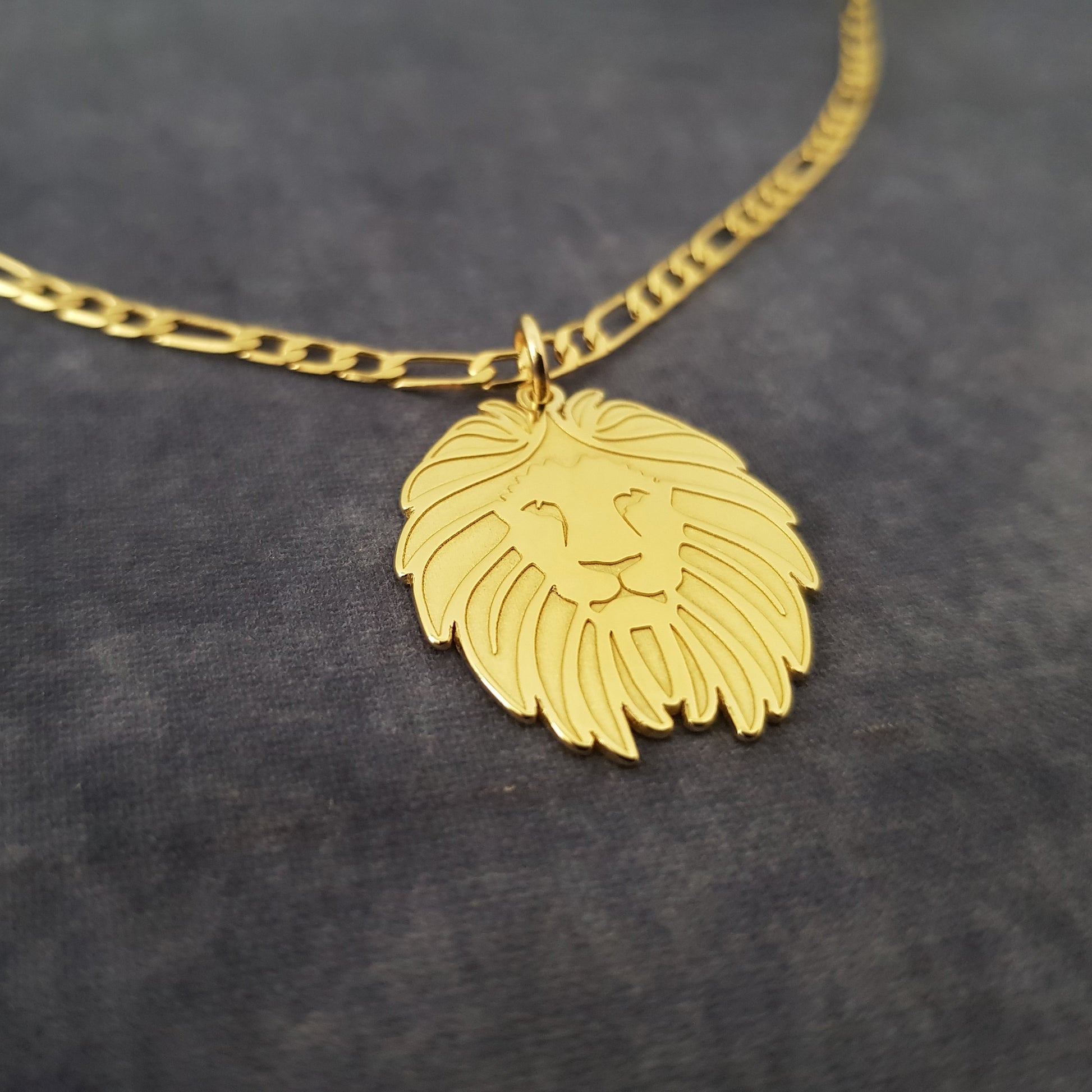 a gold necklace with a lion head on it