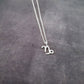 a silver necklace with the letter n on it