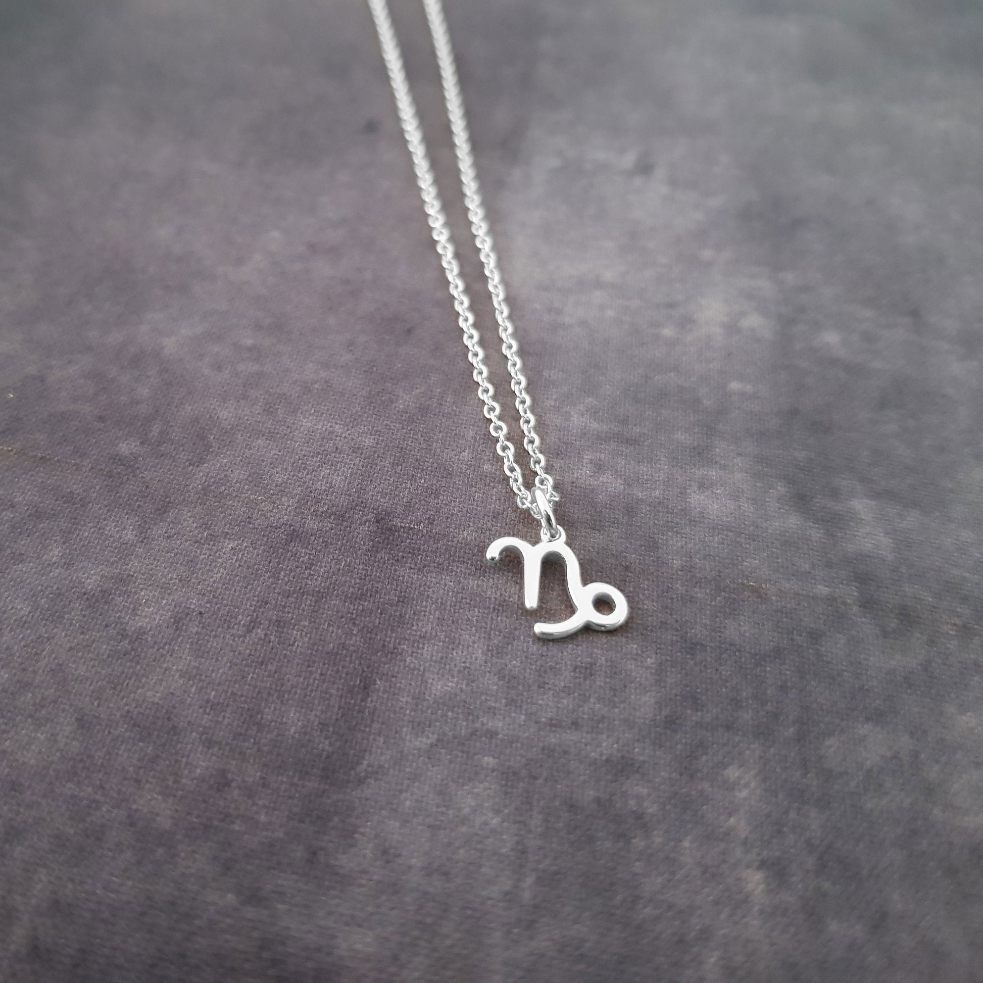 a silver necklace with the letter n on it