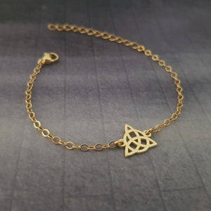 a gold bracelet with a star charm on it