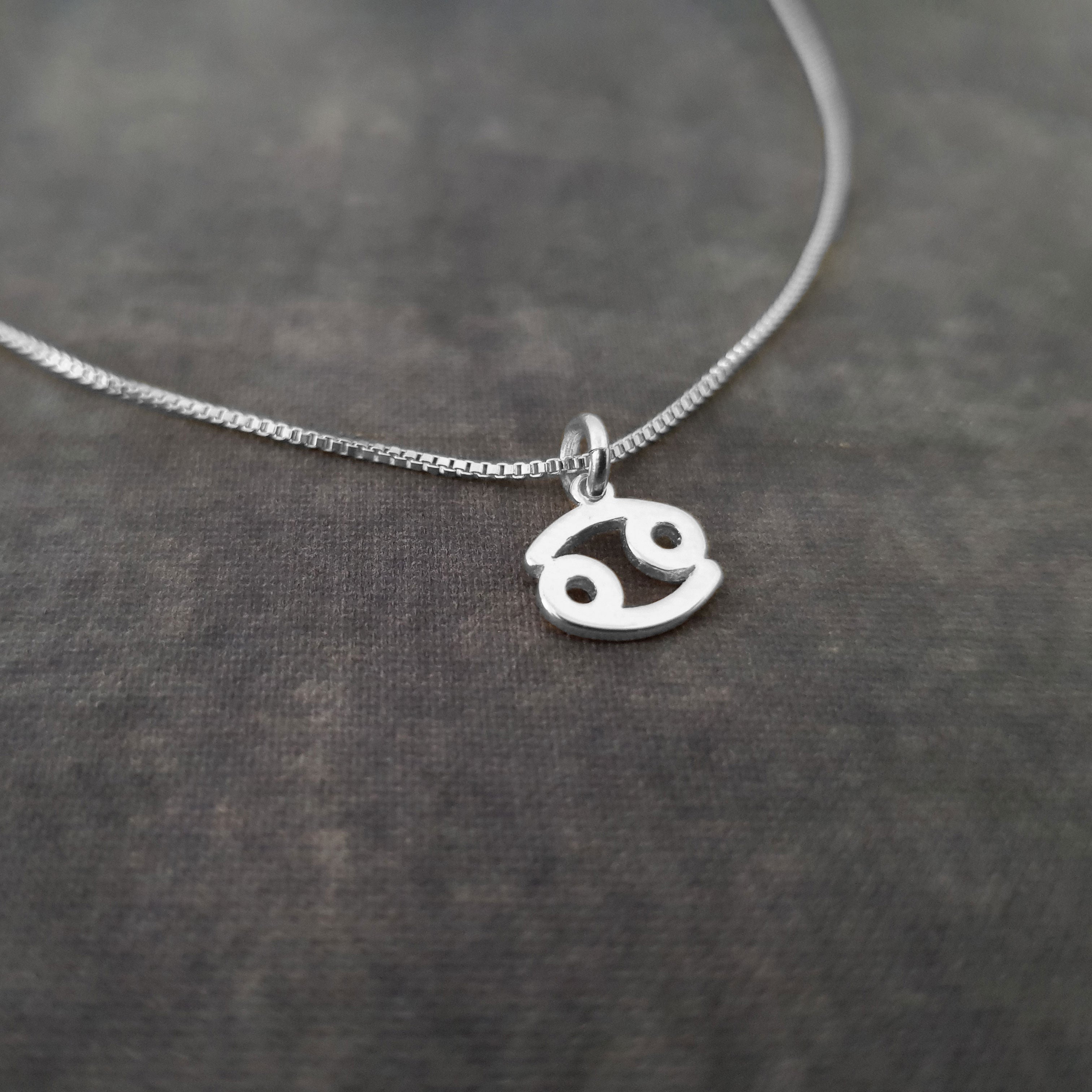 a silver necklace with a smiley face on it