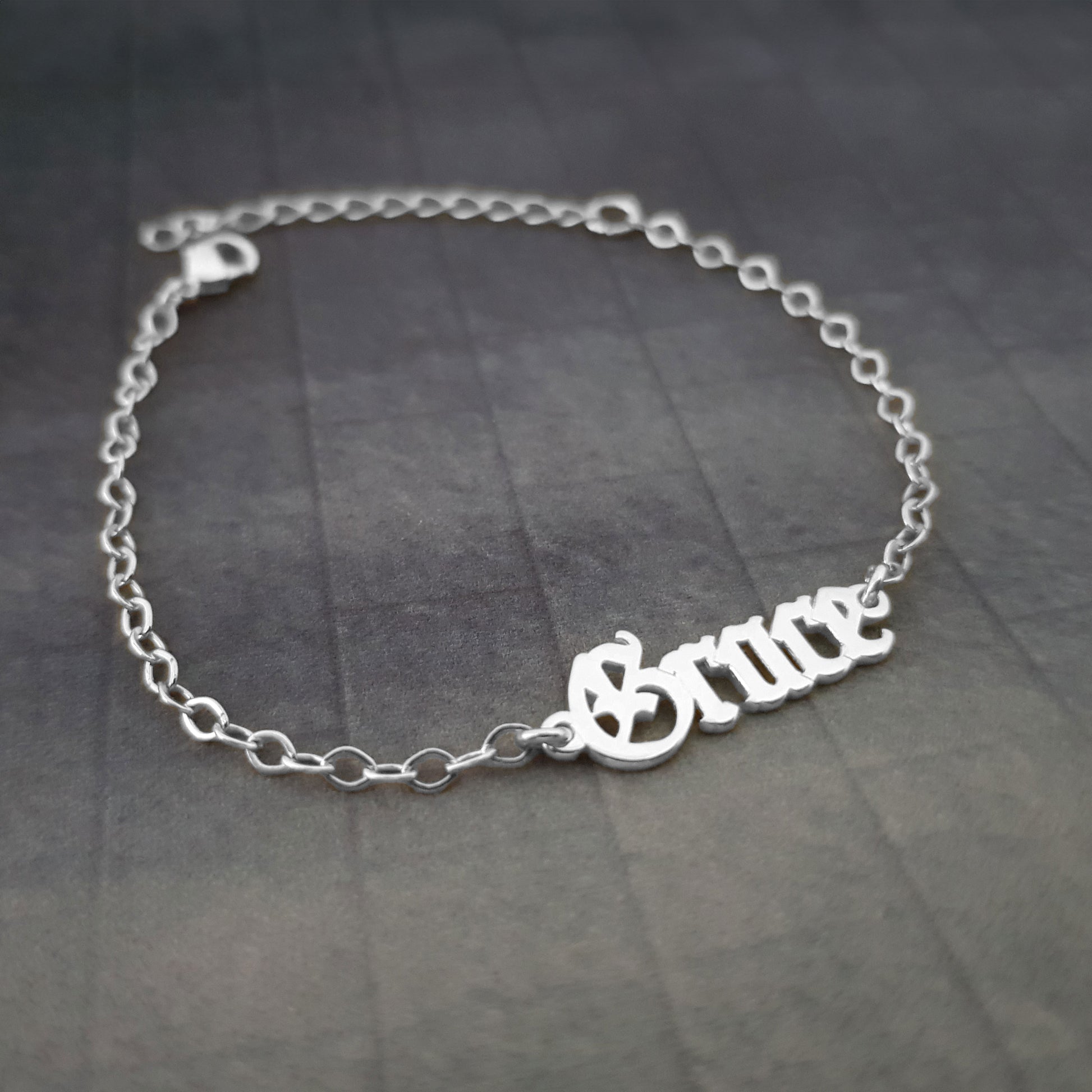 a silver bracelet with the word mom on it