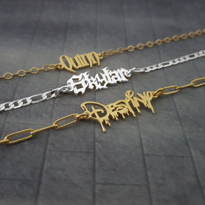 three chain bracelets with different designs on them