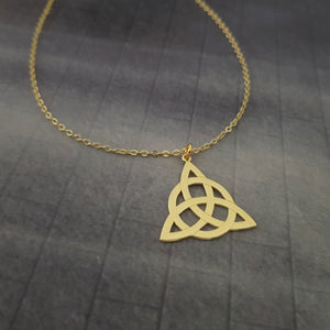 a gold necklace with a celtic knot on it