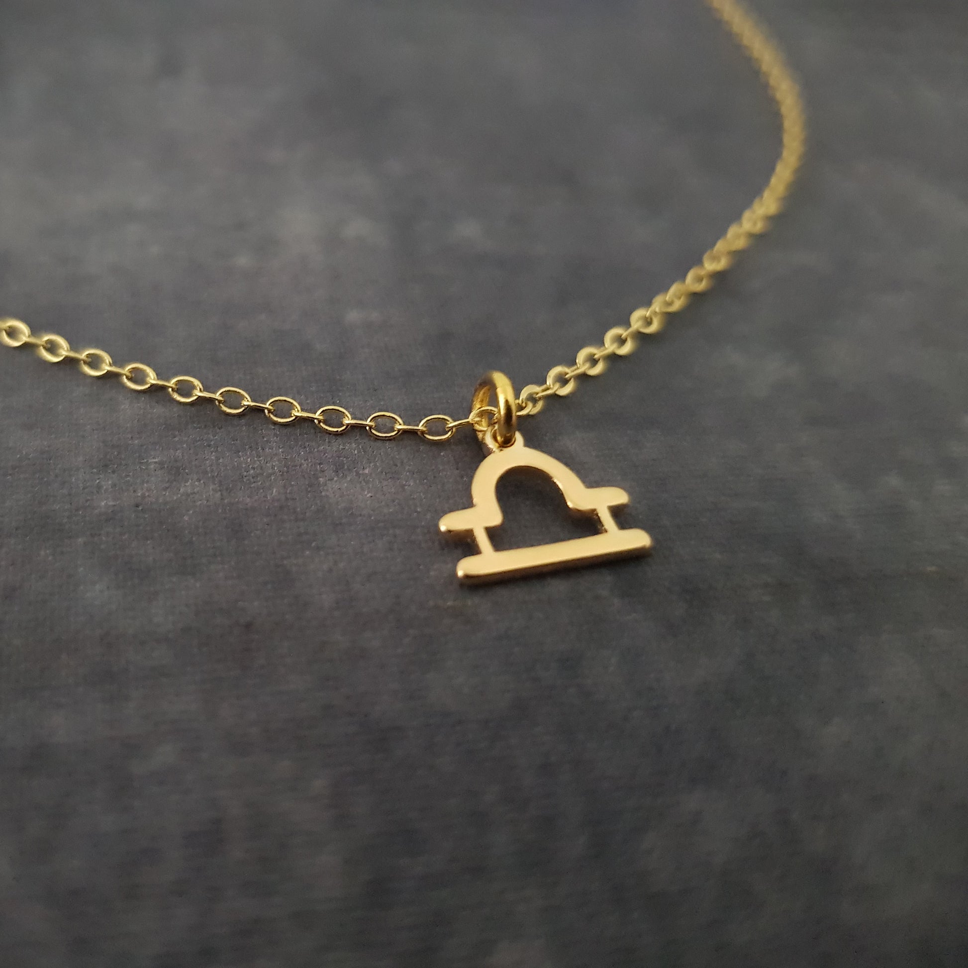 a gold necklace with a heart on it