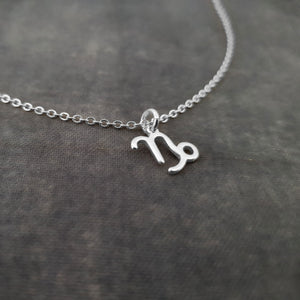 a silver necklace with the letter m on it