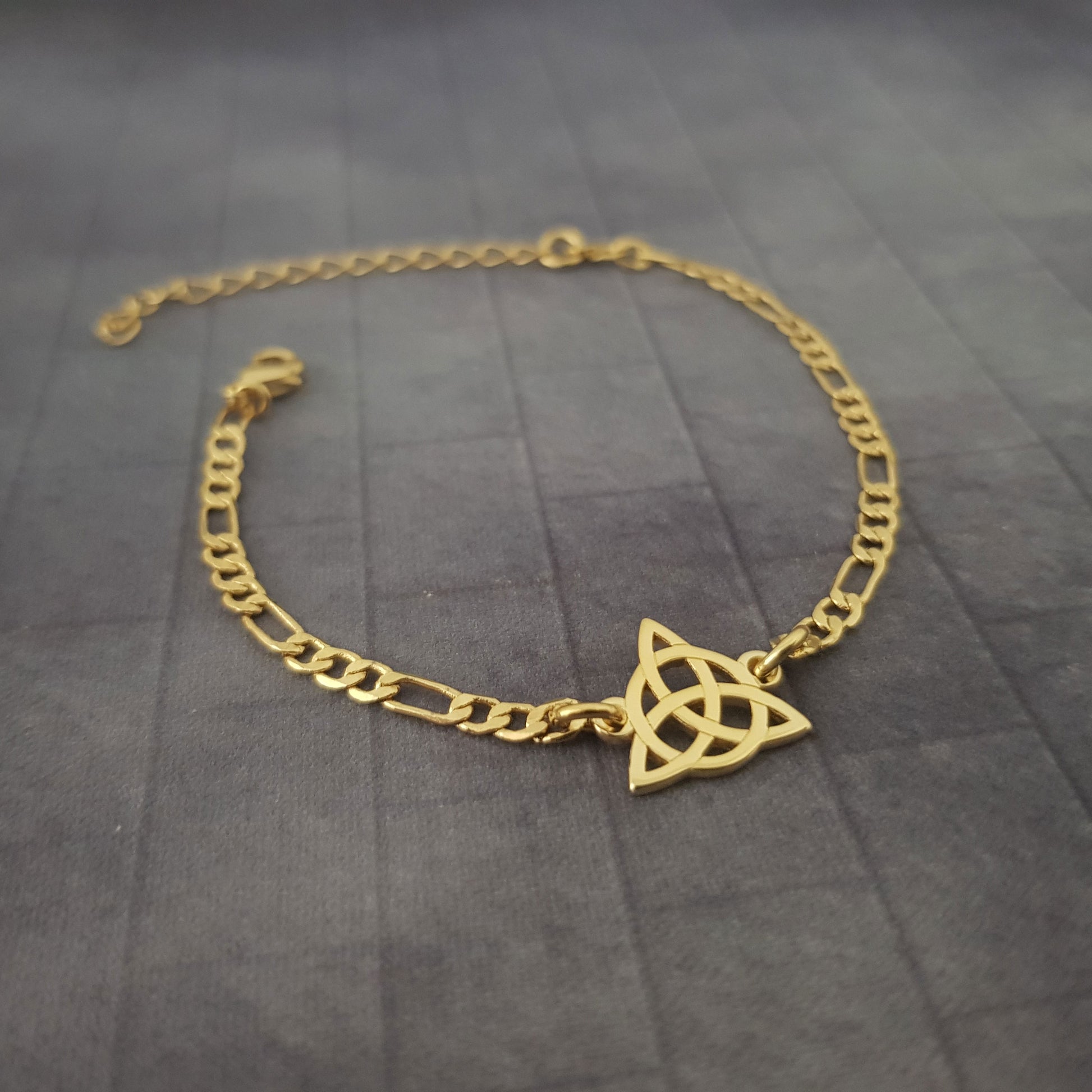 a gold bracelet with a triangle on it