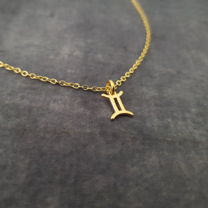 a gold necklace with a letter on it