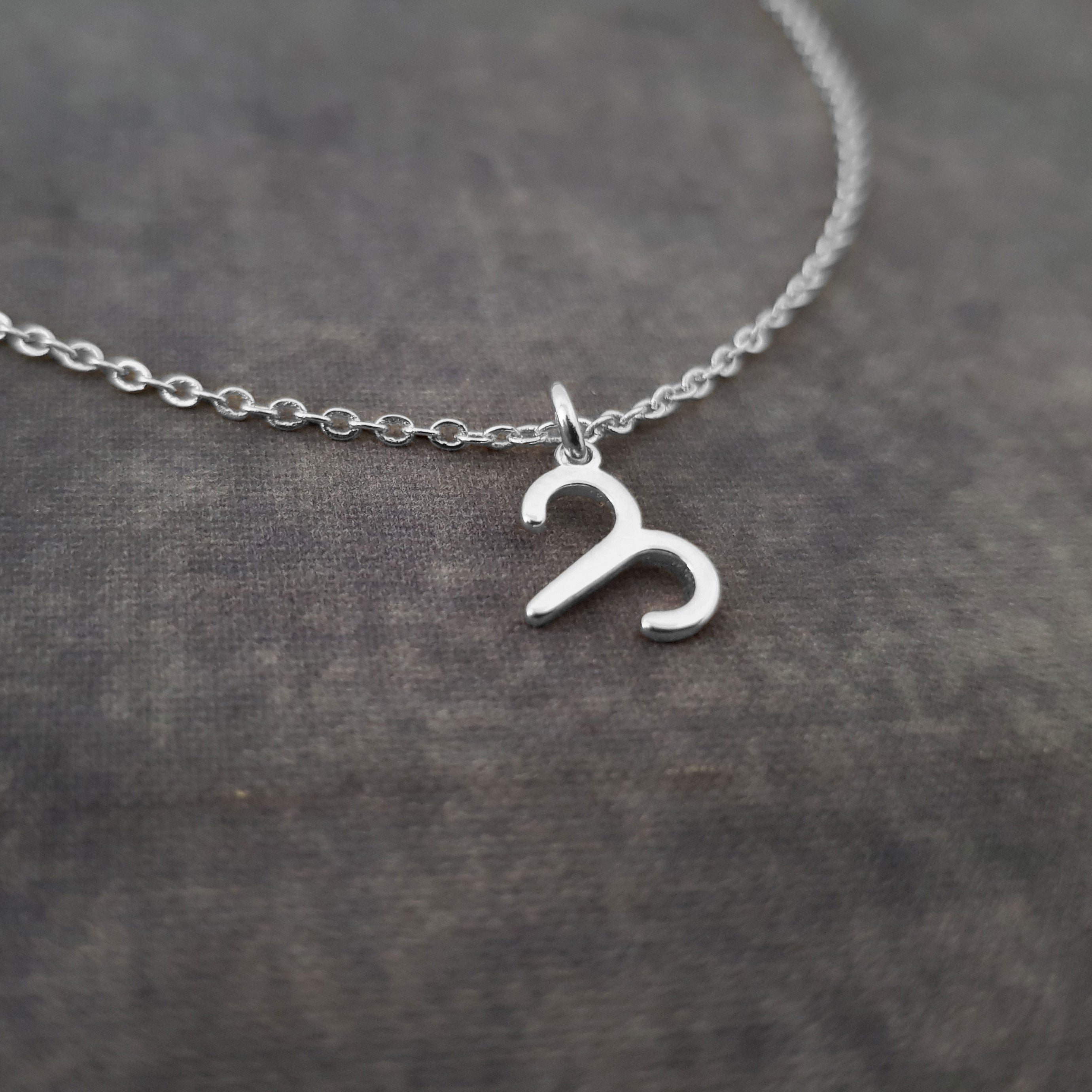 a silver necklace with the letter c on it