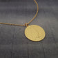 a gold necklace with a picture of a woman on it