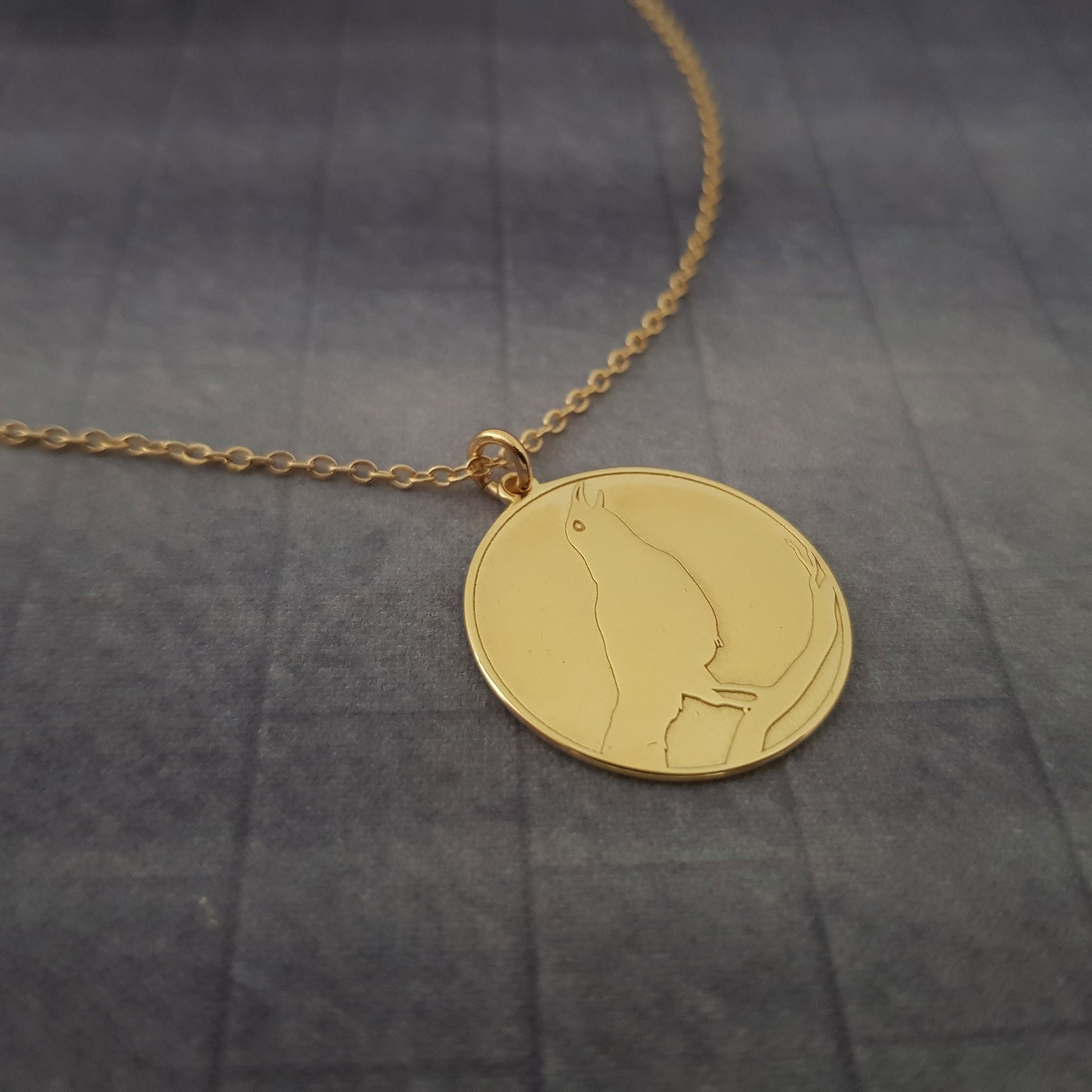 a gold necklace with a picture of a woman on it