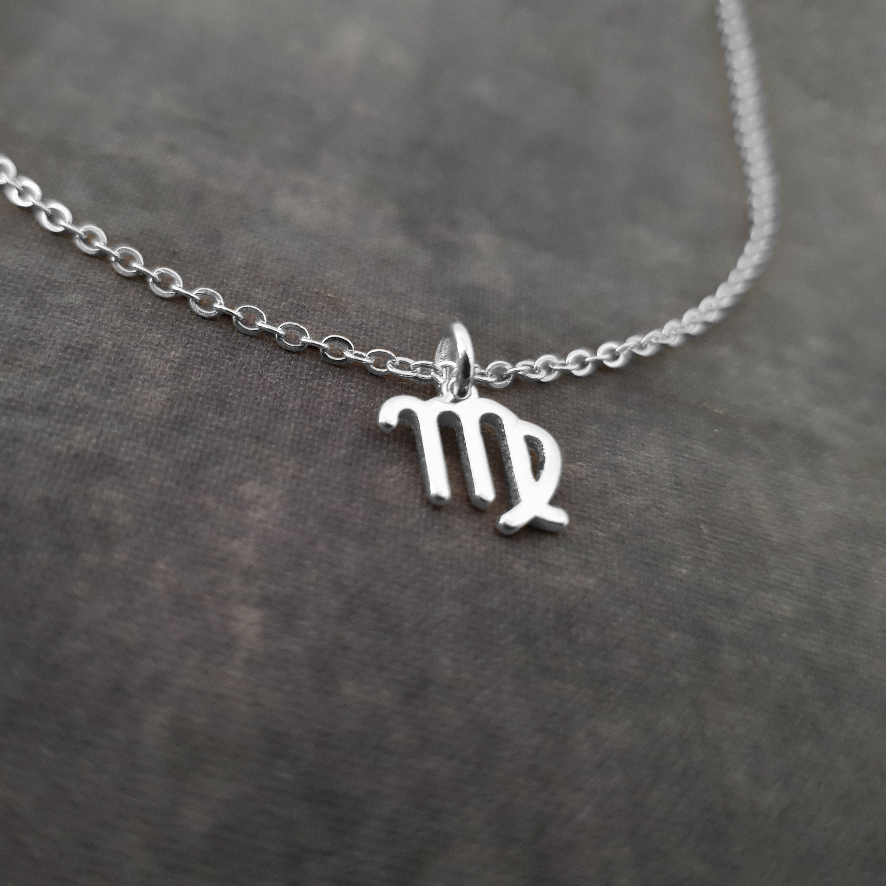 a silver necklace with the letter m on it