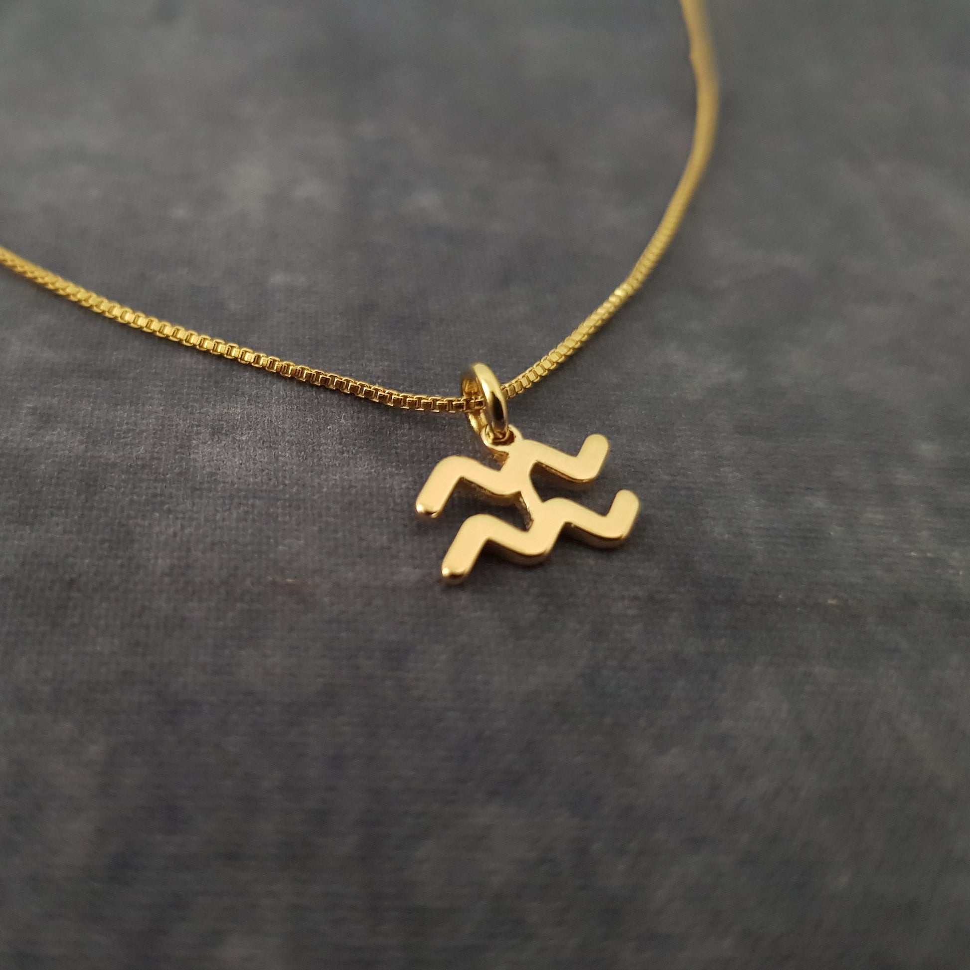 a gold necklace with two letters on it