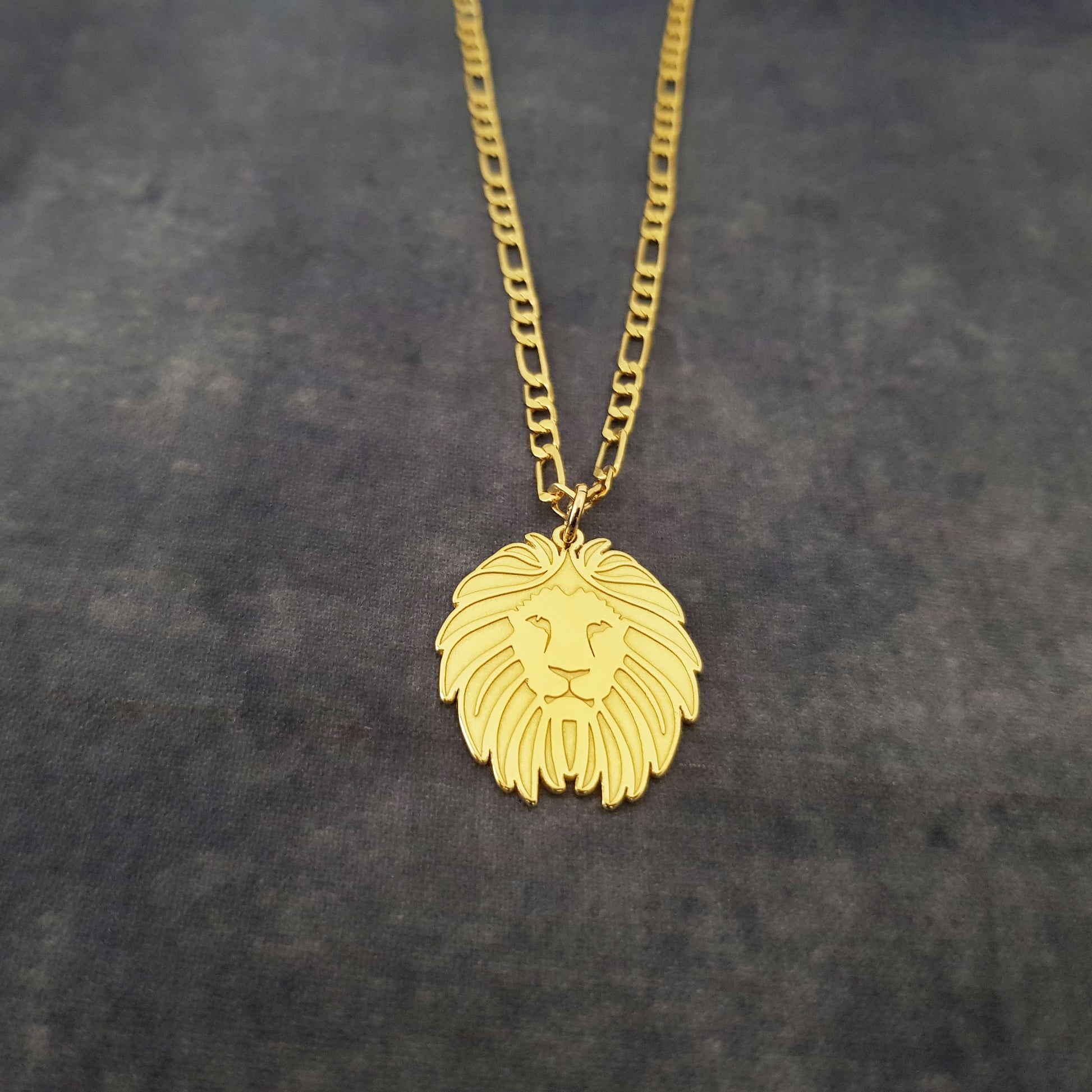 a gold necklace with a lion head on it