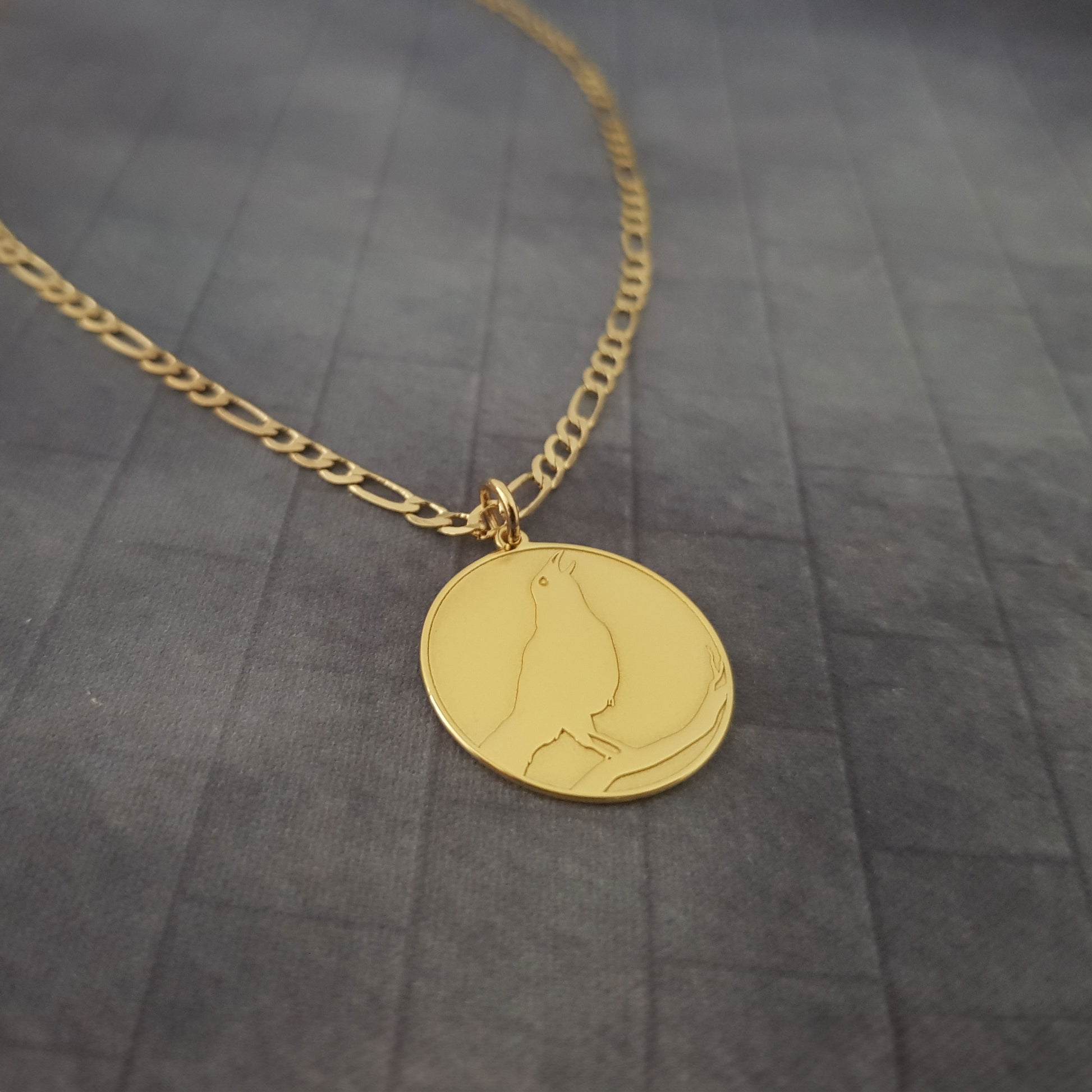 a gold necklace with a cat on it