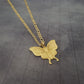 a gold necklace with a butterfly on it