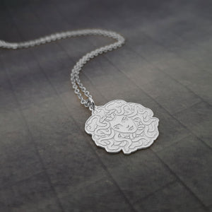 a silver necklace with an intricate design on it