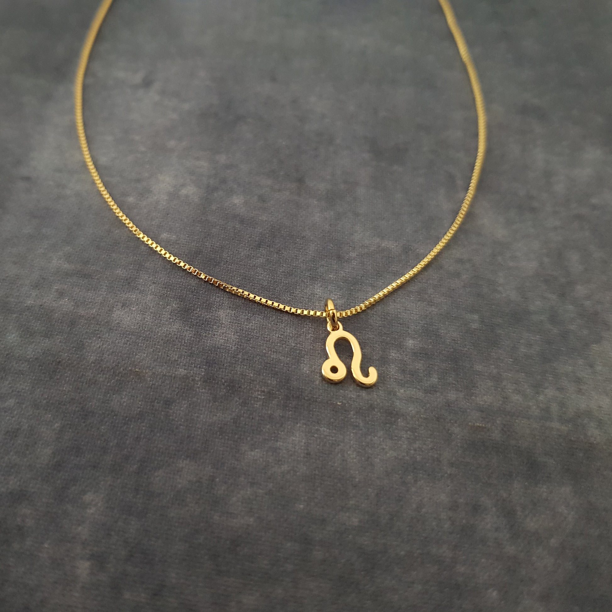 a gold necklace with a letter on it