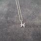 a silver necklace with a zodiac sign on it