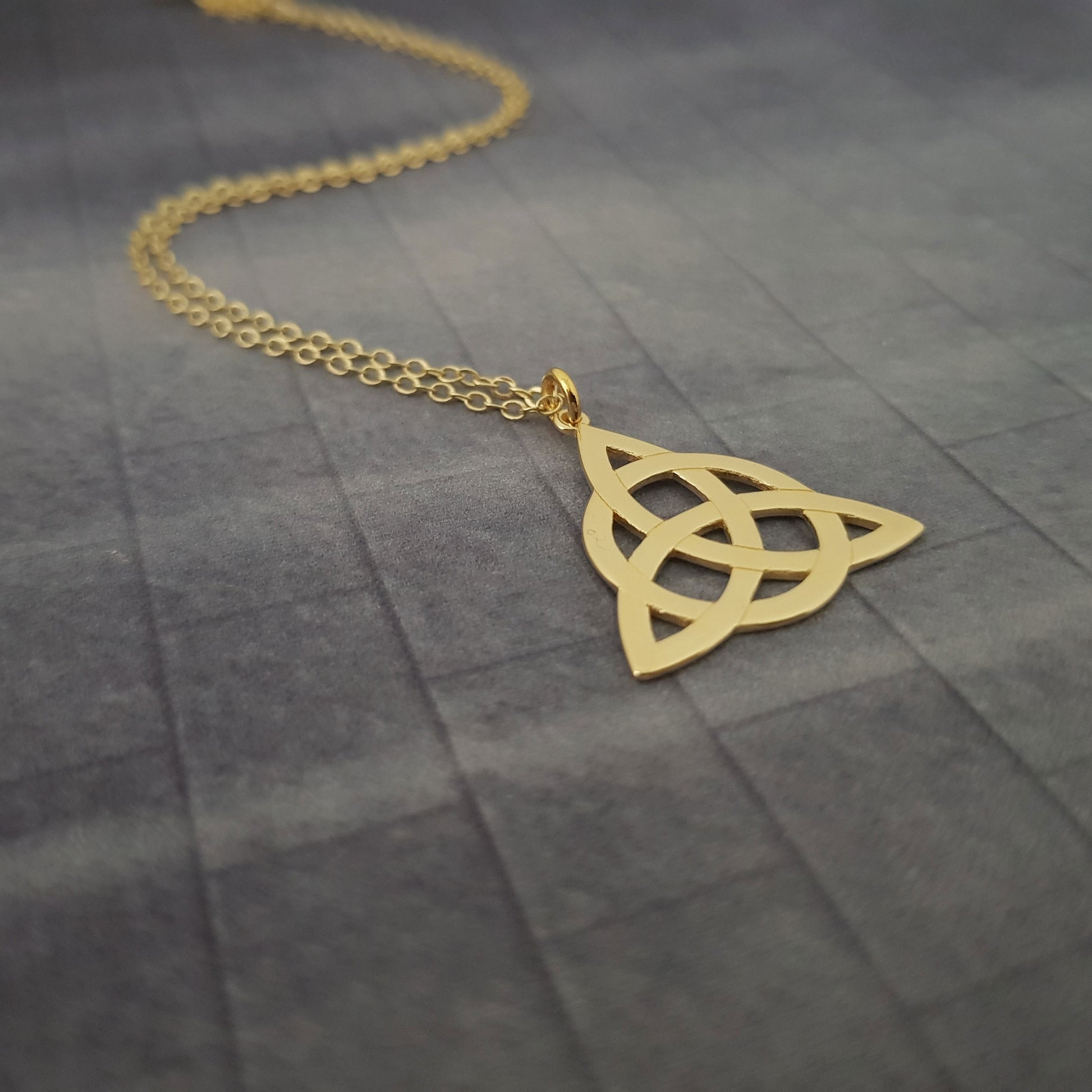 a gold necklace with a triangle on it