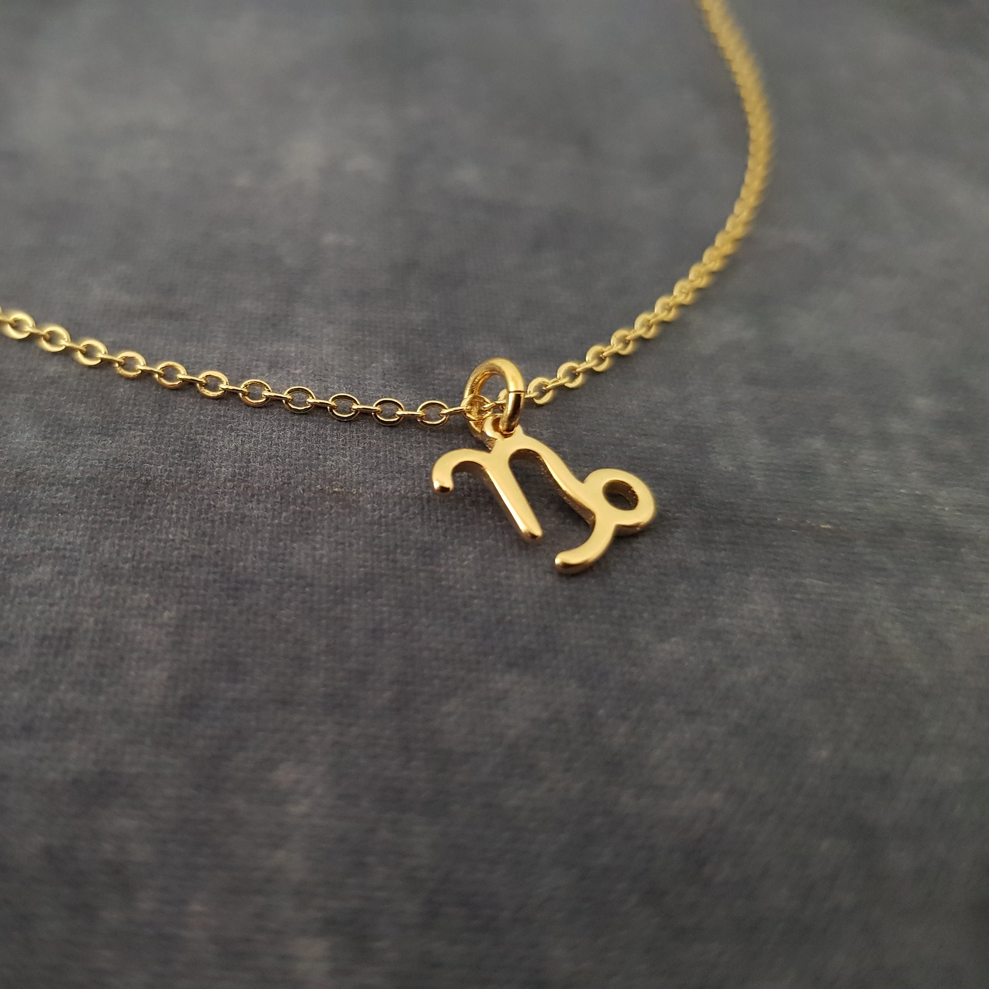 a gold necklace with the letter m on it