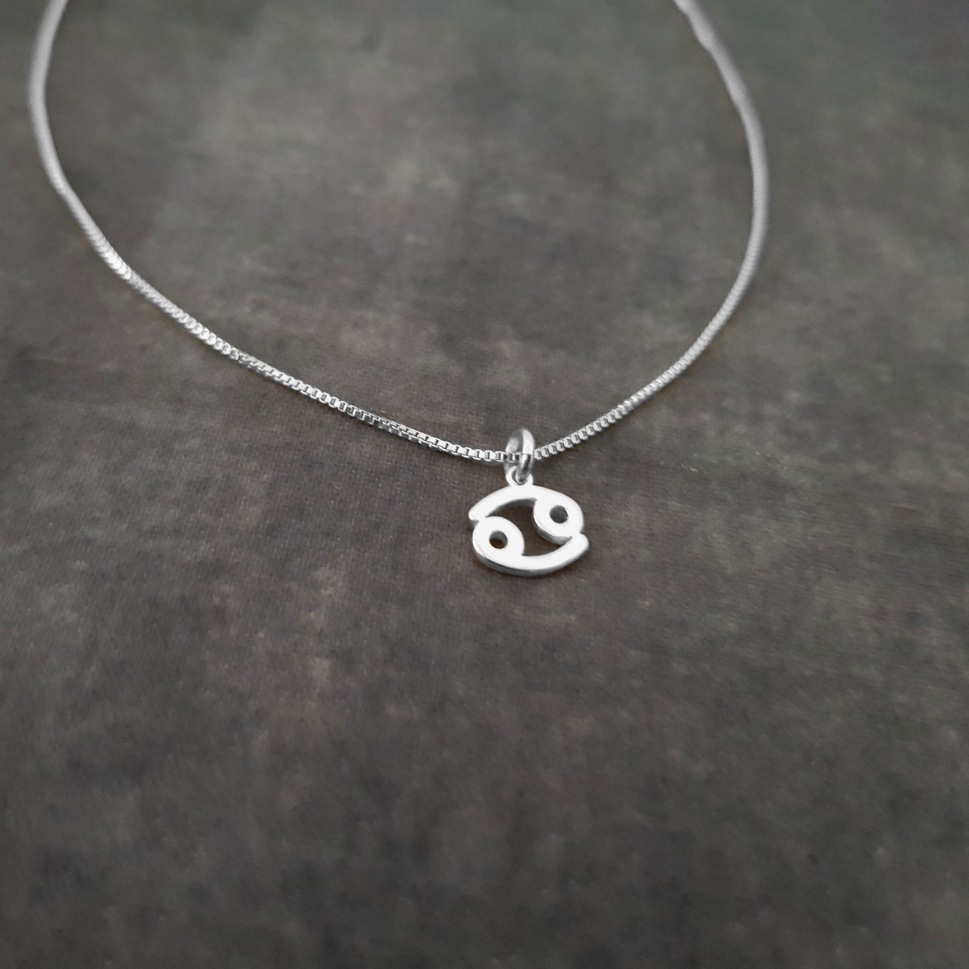 a silver necklace on a black surface