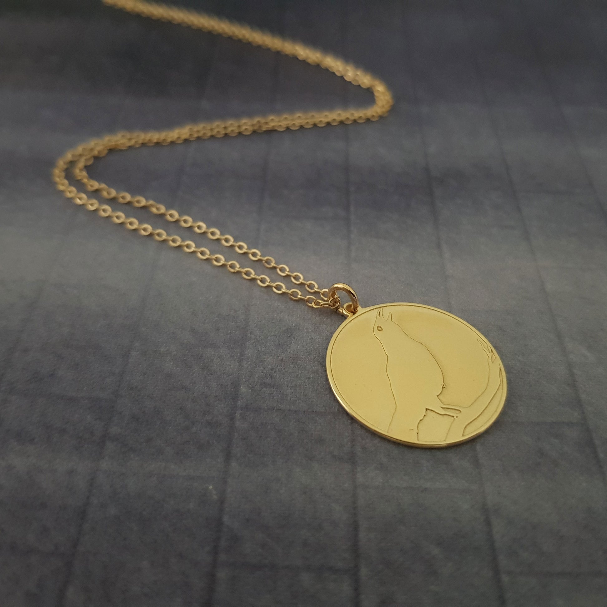 a gold necklace with a picture of a woman on it