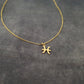 a gold necklace with a zodiac sign on it