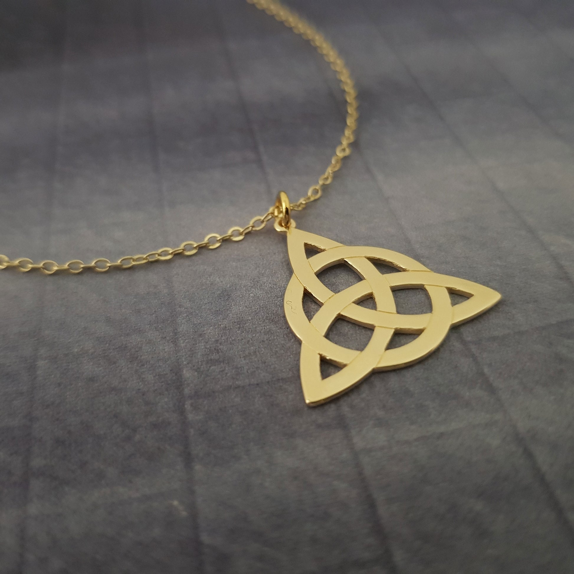 a gold necklace with an intricate design on it