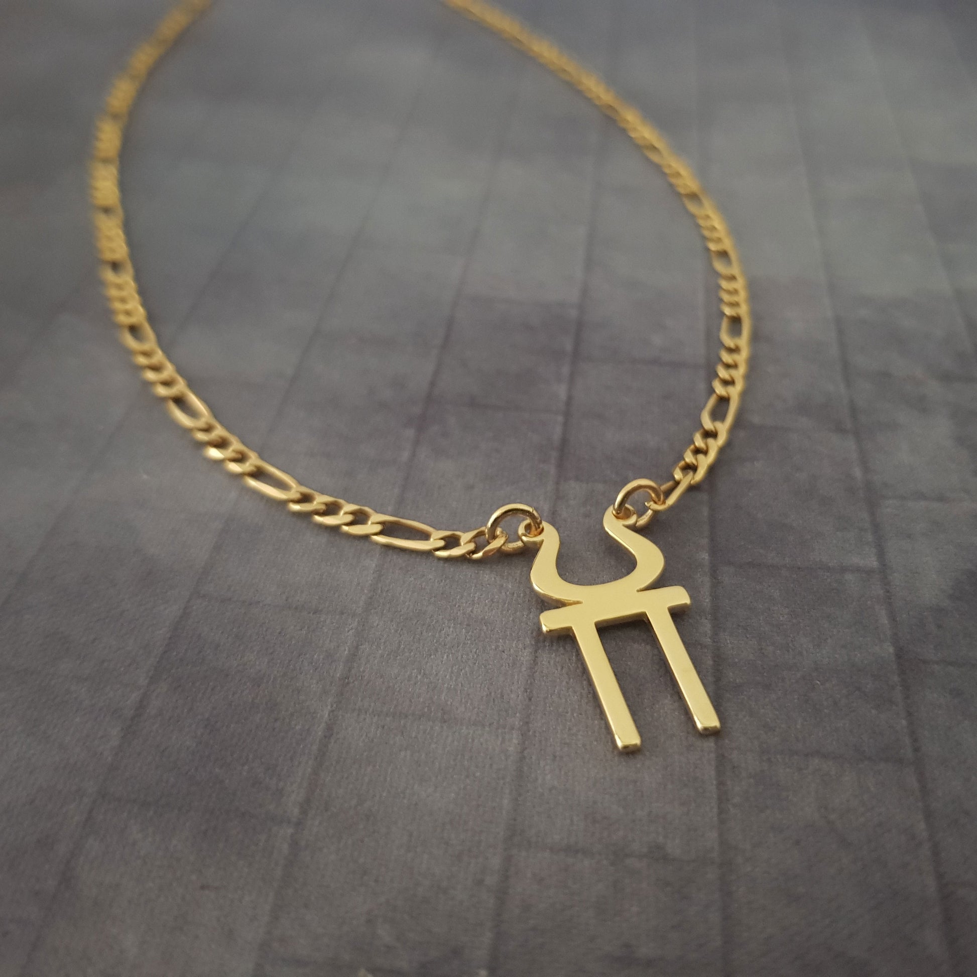 a gold necklace with a cross on it