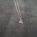 a silver necklace with the letter o on it