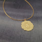 a gold necklace with a lion head on it