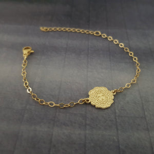 a gold bracelet with a medallion on it