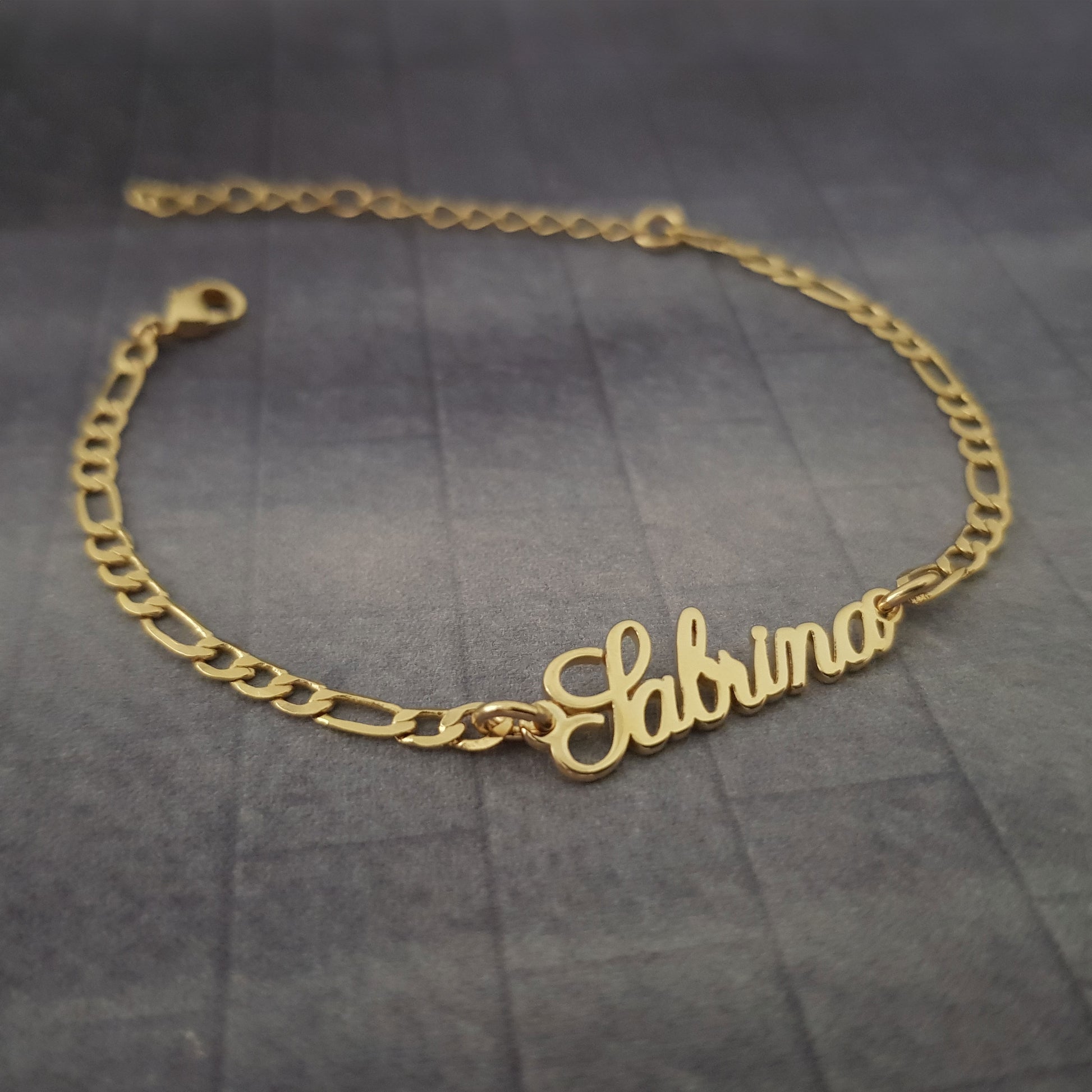 a gold bracelet with the word sabra on it