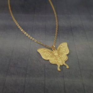 a gold necklace with a butterfly on it